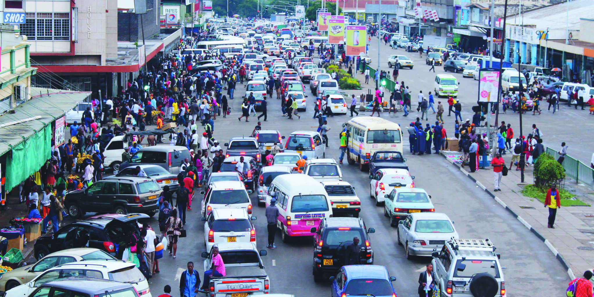 Heavy traffic and pedestrians along a busy street in Harare city centre, Zimbabwe, showing daily urban transport activity and vehicle congestion.